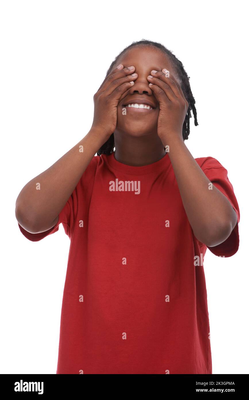 Ne jetez pas un coup d'œil... Un jeune garçon afro-américain couvrant ses yeux tout en se tenant debout sur un fond blanc. Banque D'Images