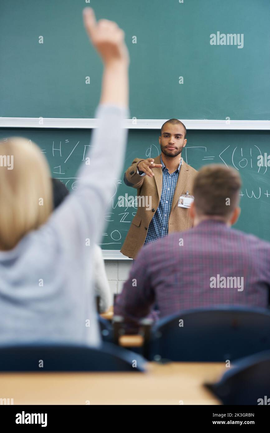 Construire des esprits brillants. Un jeune professeur de sexe masculin donne une leçon à ses élèves dans la salle de conférence. Banque D'Images
