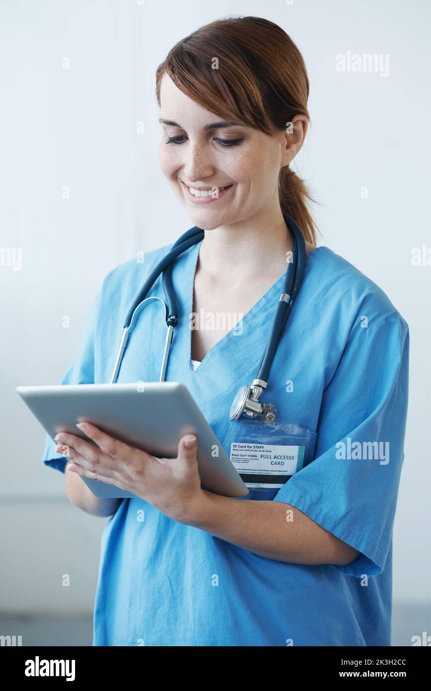 Utiliser des outils numériques pour trouver une solution. Une femme médecin travaillant sur une tablette numérique. Banque D'Images