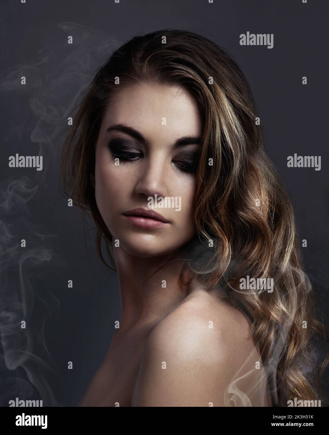 Beauté dépure. Studio photo concept d'une belle jeune femme avec la fumée qui la sort. Banque D'Images