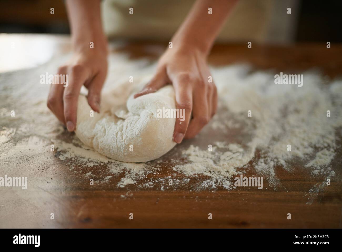 Faire son propre pain. Une boulangerie pour femme pétriant la pâte pour le pain fait maison. Banque D'Images
