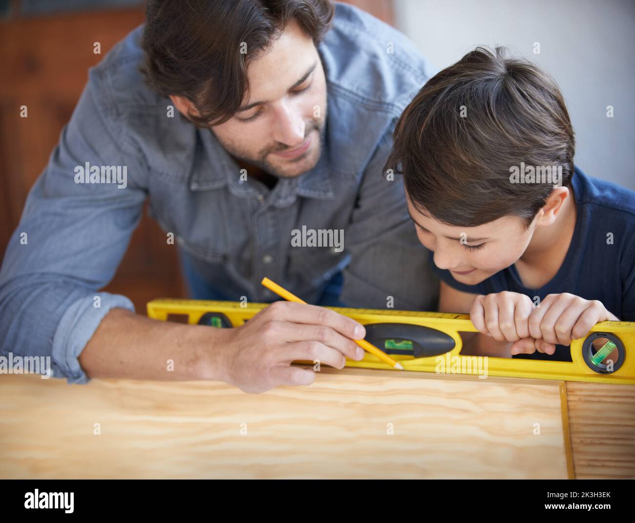 Lui montrant comment faire du bricolage. Un père et un fils qui font du travail du bois ensemble. Banque D'Images