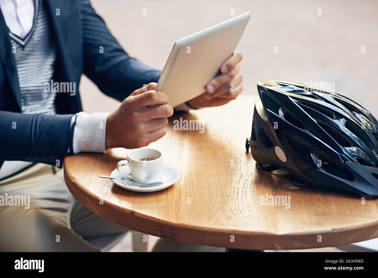 Faire une pause café. Un homme d'affaires utilisant sa tablette numérique tout en prenant un café dans un café extérieur. Banque D'Images
