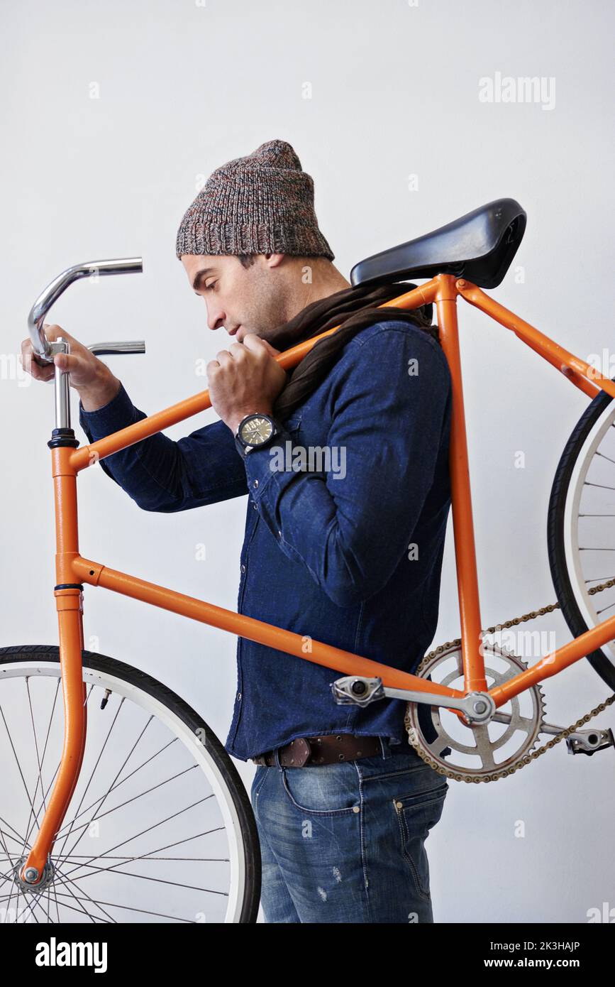 Il se met à travailler avec la puissance de l'homme, un jeune homme branché portant son vélo. Banque D'Images