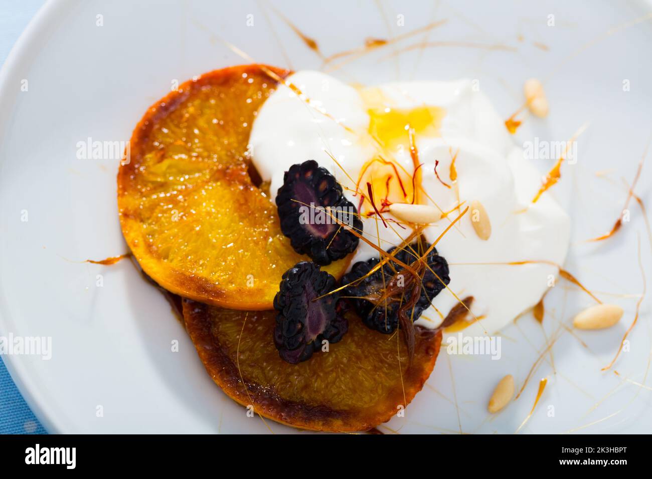Dessert d'oranges caramélisées, de mûres et de yaourts Banque D'Images