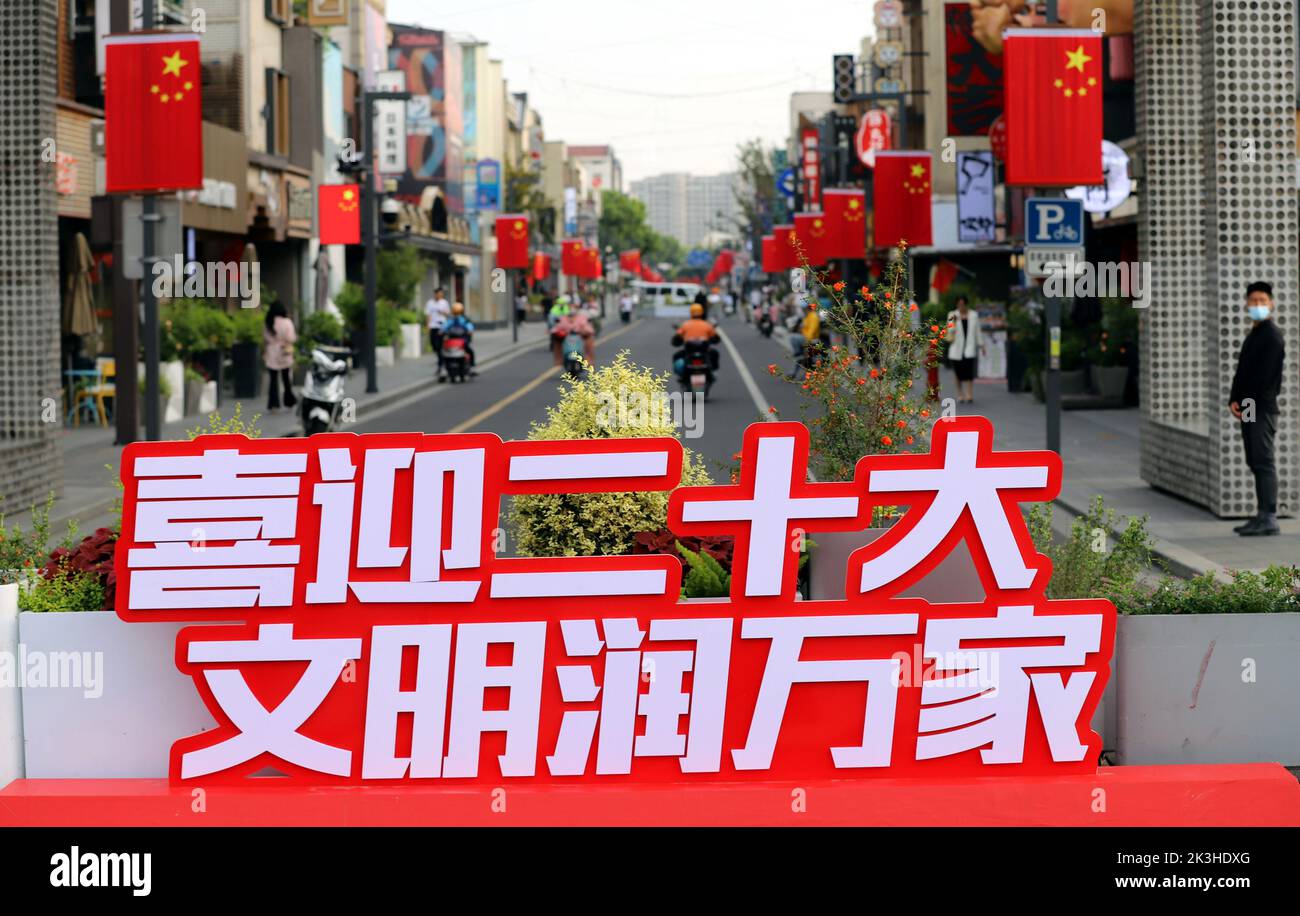 SUZHOU, CHINE - le 26 SEPTEMBRE 2022 - les gens passent sous les drapeaux nationaux suspendus sur la rue Huaihai à Suzhou, province du Jiangsu, Chine, le 27 septembre 2022. Banque D'Images