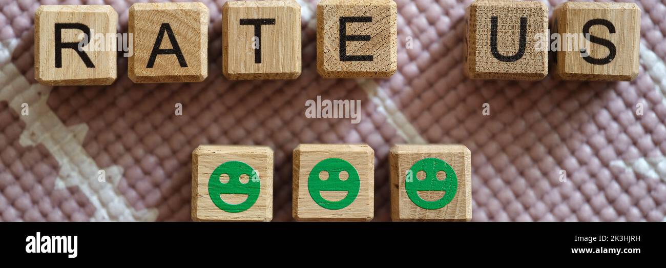Notez-nous l'inscription sur les cubes et les émoticônes vertes souriantes Banque D'Images Notez-nous l'inscription sur les cubes et les émoticônes vertes souriantes Banque D'Images