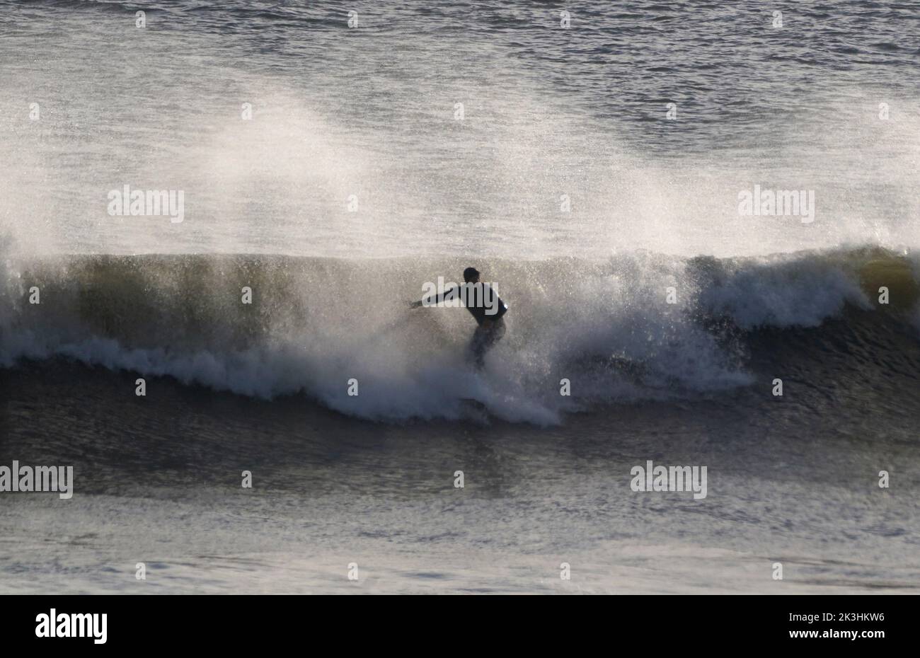 Un surfeur qui fait une vague sur la mer à la plage de Tynemouth sur la côte nord-est. Date de la photo: Mardi 27 septembre 2022. Banque D'Images