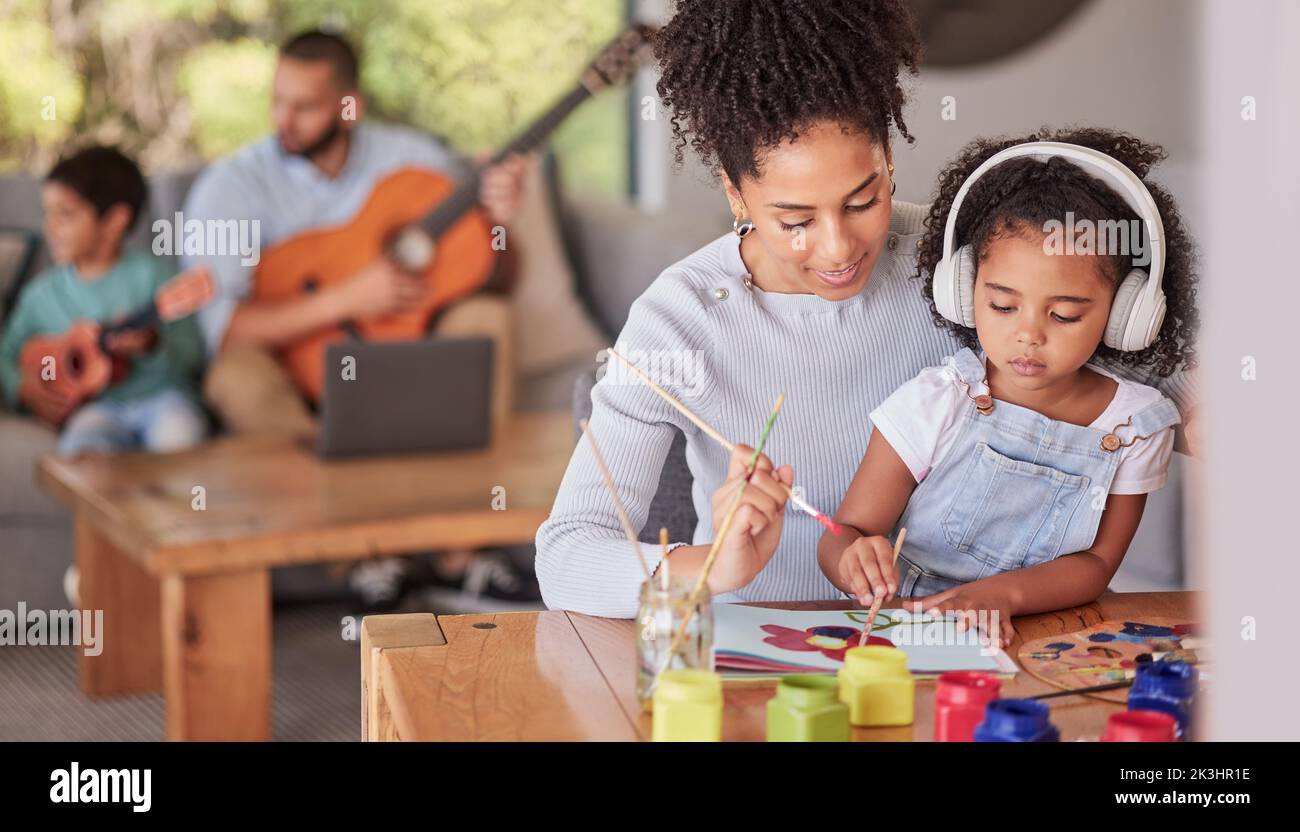 Famille créative, maman et fille faisant l'art et l'artisanat avec papa et en arrière-plan avec la guitare à la maison. La peinture, le développement de l'enfant et les parents aiment pour Banque D'Images