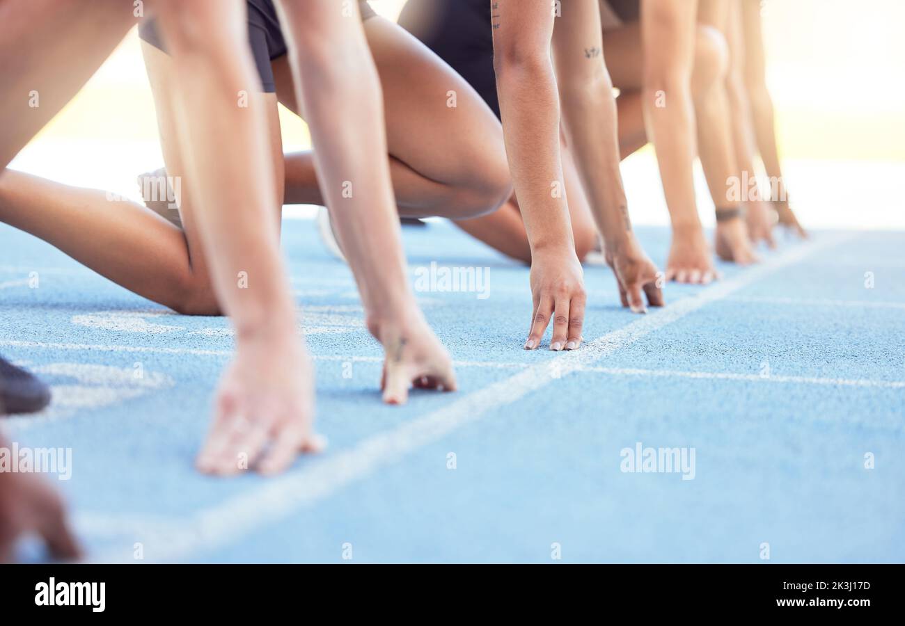 Coureurs avec les mains sur la ligne de départ sur la piste pour une course, prêt à courir. Défi de course ou sprint à un événement sportif avec gros plan pour la motivation Banque D'Images