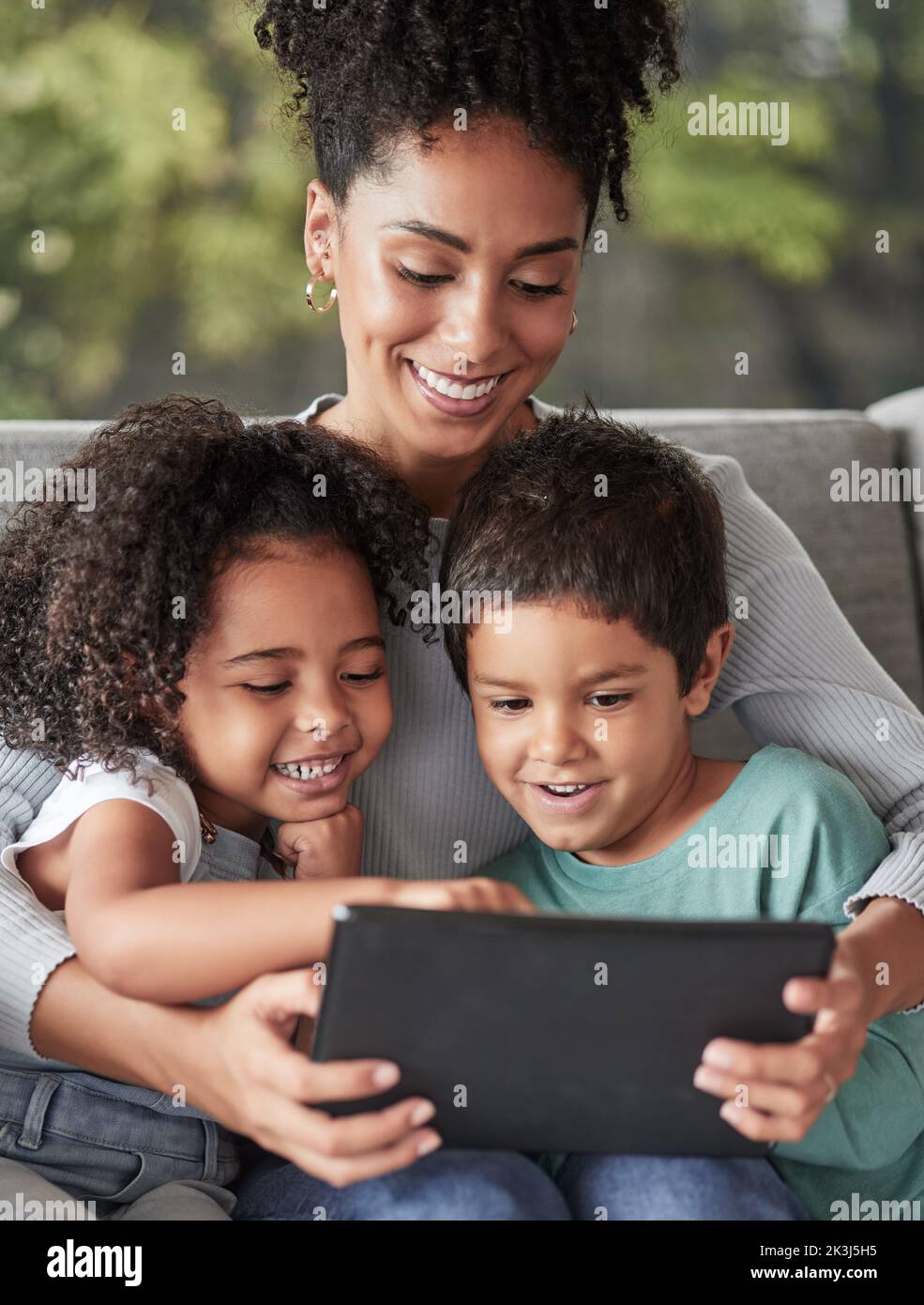 Famille, détente et tablette avec mère et enfants assis sur un canapé pour la technologie, l'éducation ou Internet ensemble. Jeux, films ou numériques avec maman et Banque D'Images