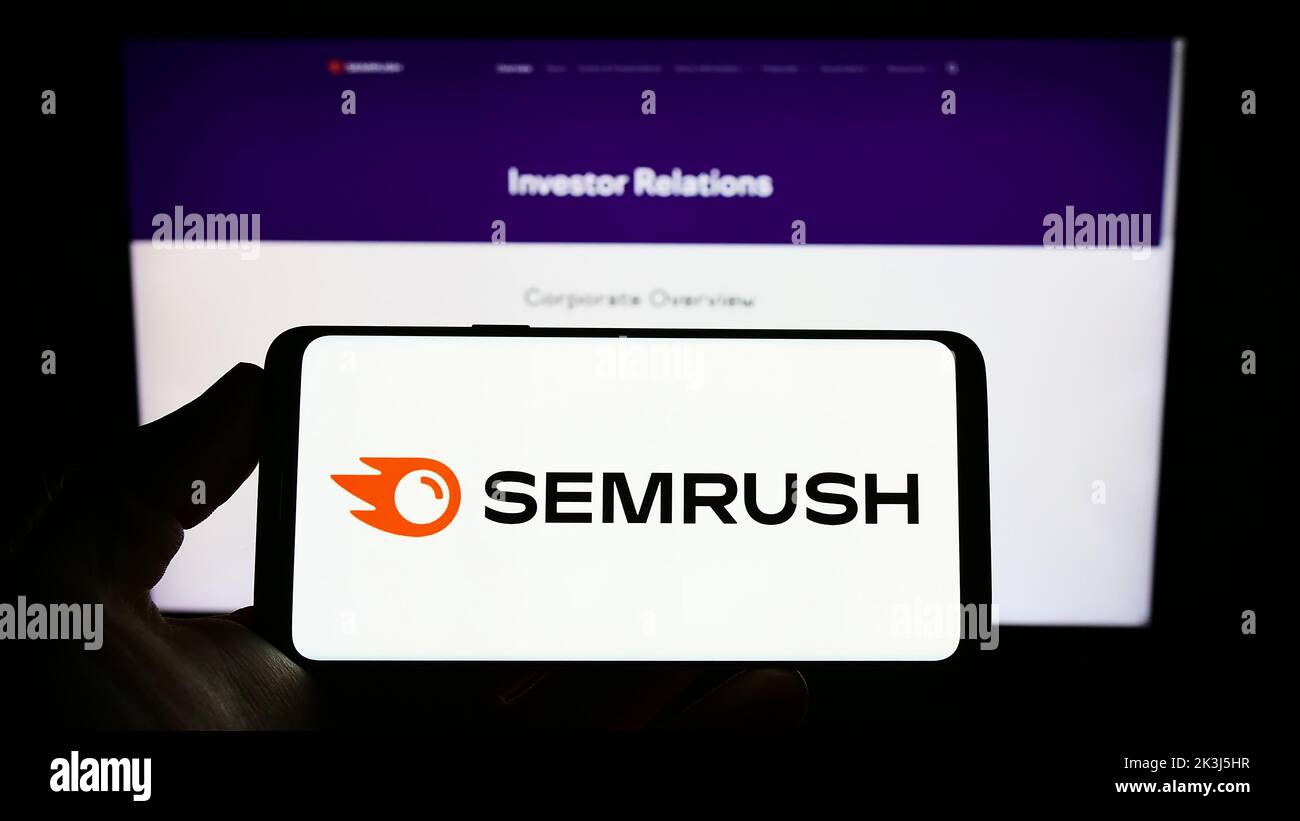 Personne tenant un smartphone avec le logo de la société américaine de marketing de Search Engine SEMrush Inc. À l'écran devant le site Web. Mise au point sur l'affichage du téléphone. Banque D'Images