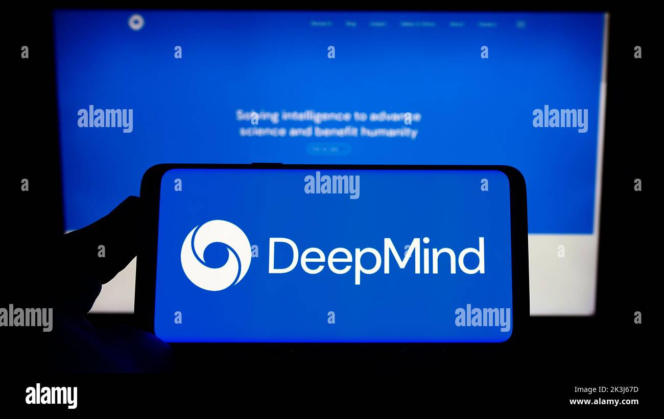 Personne tenant un smartphone avec le logo de la société ai DeepMind technologies Limited à l'écran devant le site Web. Mise au point sur l'affichage du téléphone. Banque D'Images