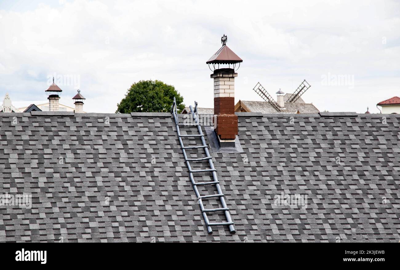 toit en galets. Ancienne méthode de fabrication de toits à partir de bois, de fond. Échelle de toit et cheminée Banque D'Images