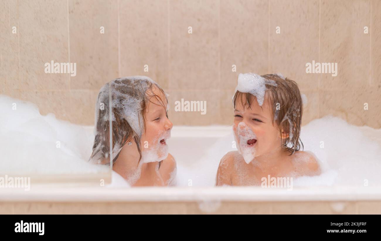Mignons sœurs filles dans le bain avec savon mousse Banque D'Images