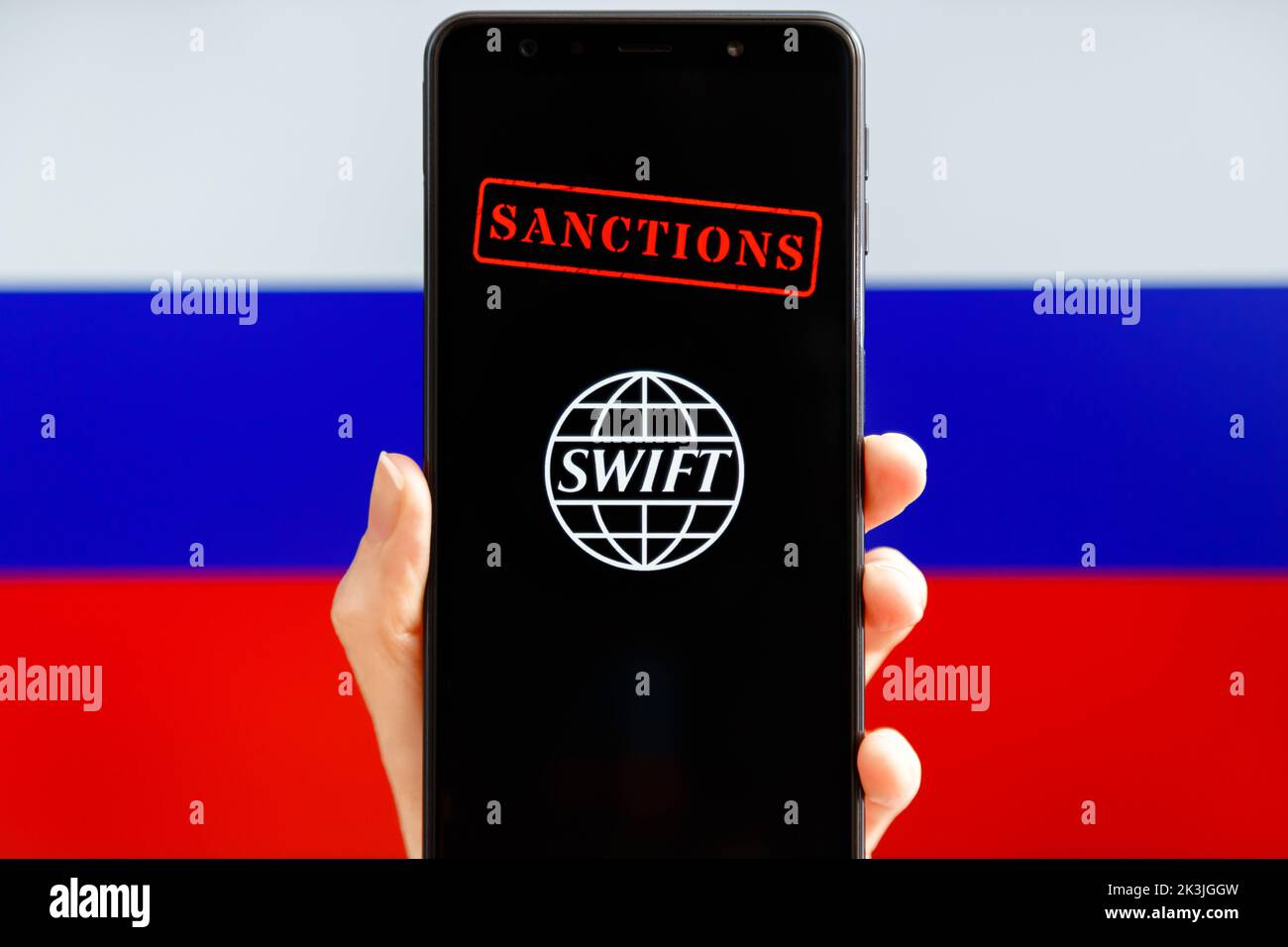 Ukraine, Kiev - février 23 2022 : portable avec logo SWIFT, sanctions et drapeau russe en arrière-plan. Sanctions contre la Russie, déconnexion du concept SWIFT. Banque D'Images