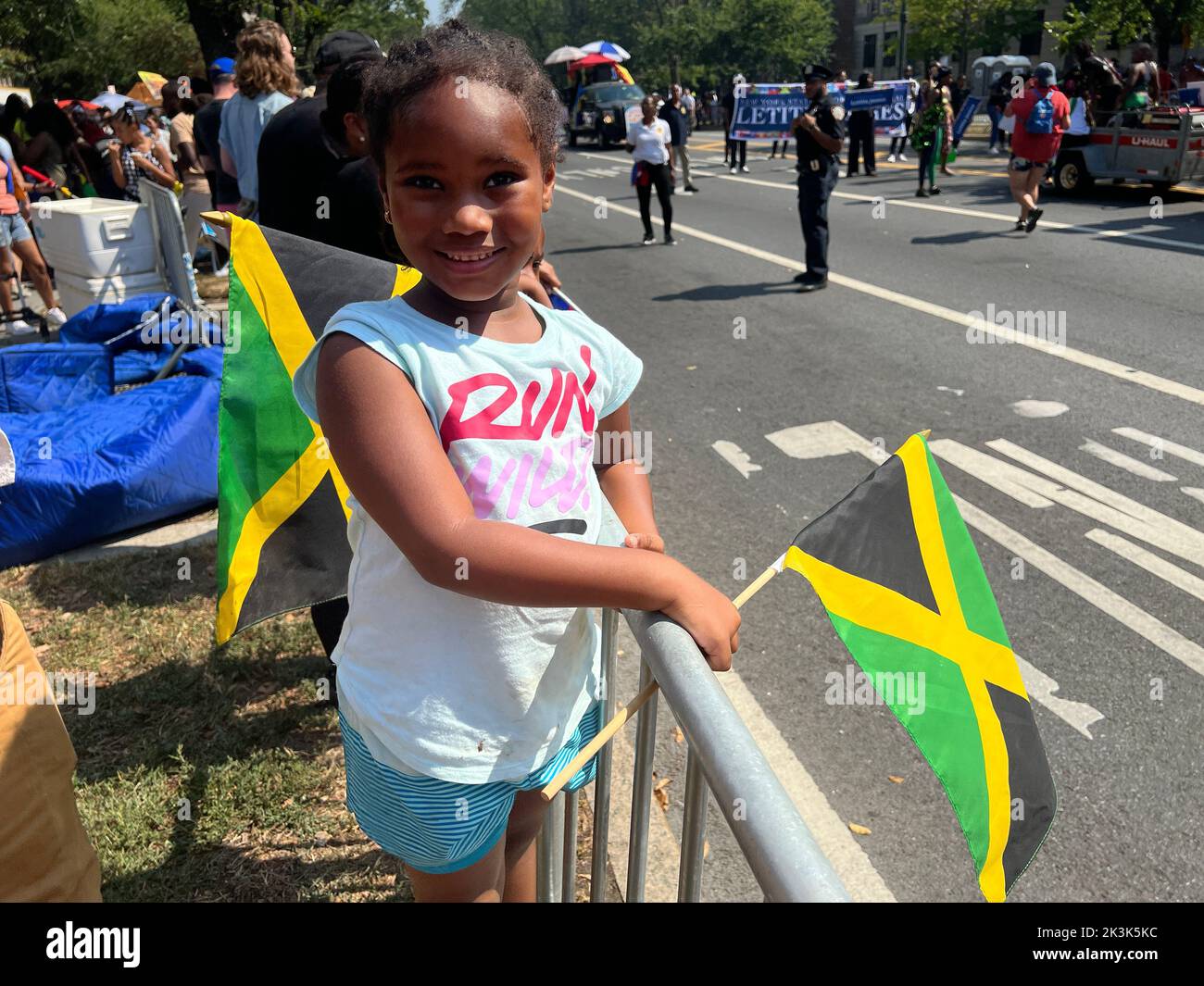 Un enfant tient un drapeau jamaïcain en attendant que LE DÉFILÉ DES CARAÏBES INDIENNES DE L'OUEST passe le long de Eastern Parkway à Brooklyn, New York. Banque D'Images
