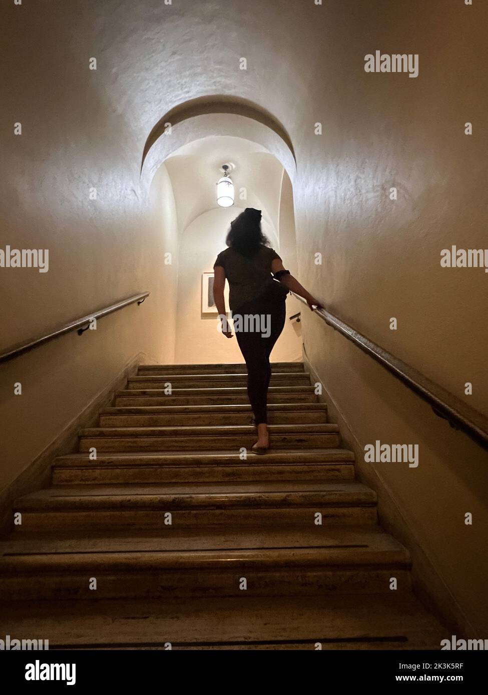 Une femme monte un escalier à la Morgan Library and Museum de New York. Banque D'Images