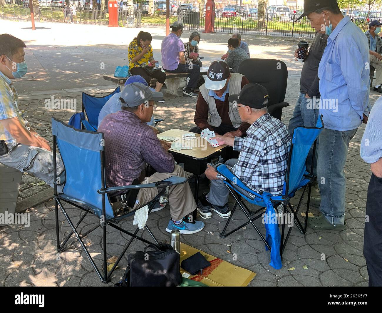Des hommes se détendent dans le parc Lief Erickson à Brooklyn lors d'un jeu de cartes convivial. Banque D'Images