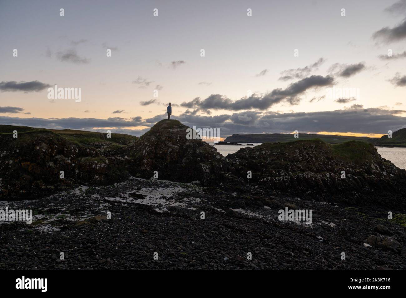 2022 septembre : Île de Canna, Hébrides intérieures, Écosse Un jeune garçon se tient sur les rochers Banque D'Images