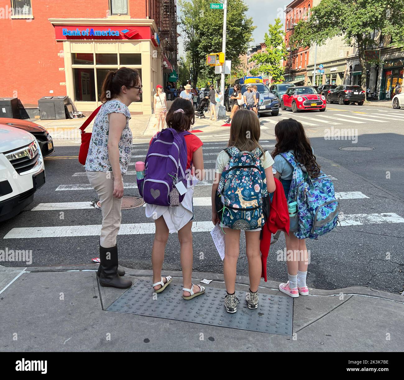 Enfants avec des sacs de livres attendant de traverser la rue après l'école dans le quartier Park Slope, Brooklyn, New York. Banque D'Images