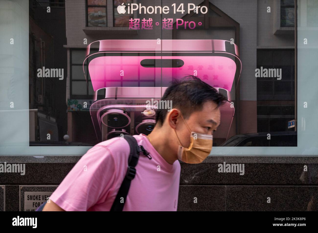 Un piéton passe devant une publicité commerciale Apple iPhone 14 Pro, société multinationale américaine de technologie, à Hong Kong. Banque D'Images
