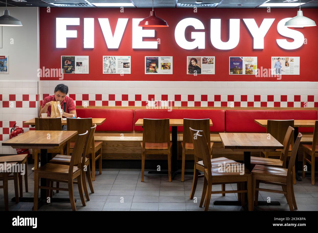 Un client mange dans la chaîne américaine de restaurants de hamburgers rapides et décontractés cinq gars à Hong Kong Banque D'Images