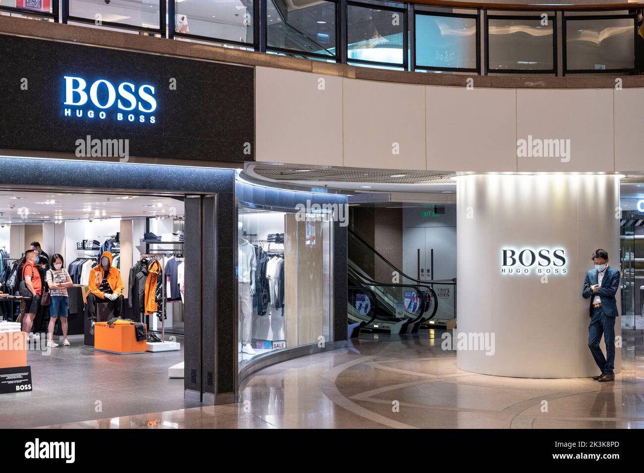 Un acheteur portant un costume est vu à l'extérieur de la marque de vêtements allemande Hugo Boss magasin à Hong Kong. Banque D'Images