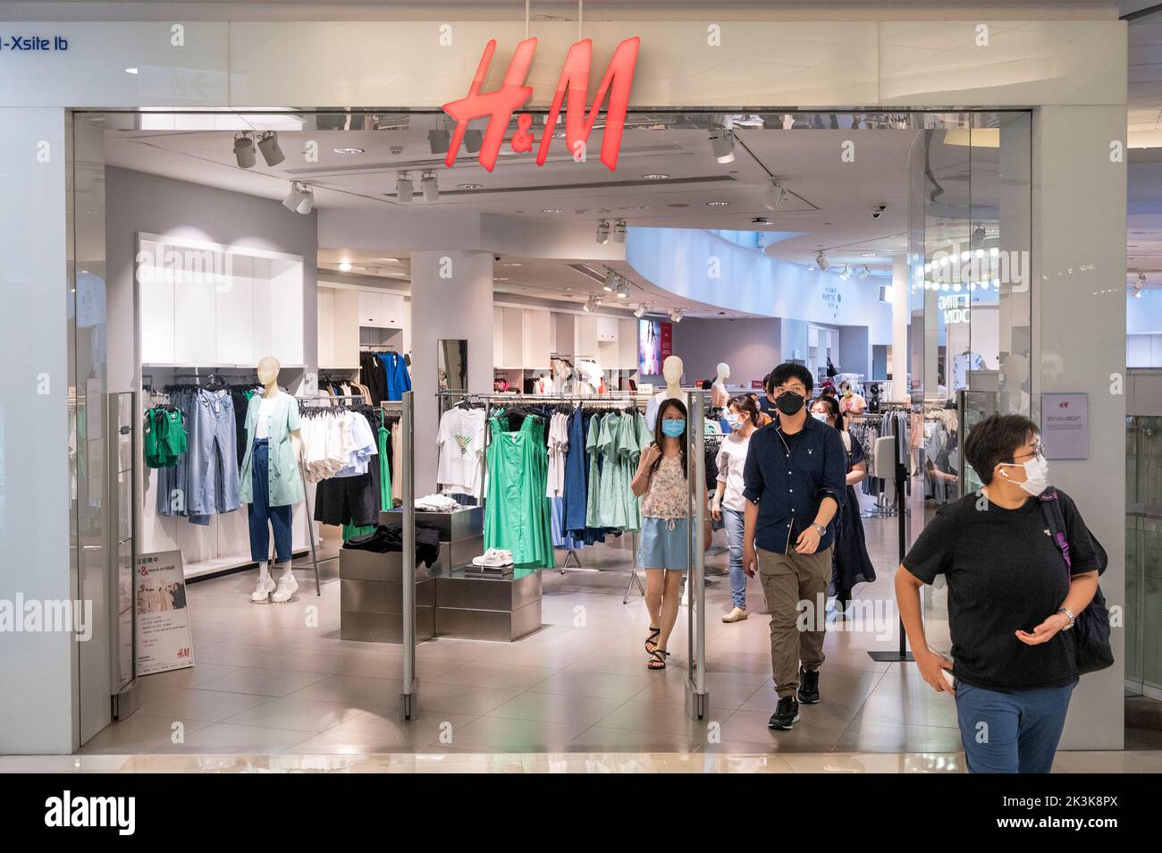 Les acheteurs quittent la société suédoise de vente au détail de vêtements multinationaux Hennes & Mauritz, magasin H&M à Hong Kong Banque D'Images