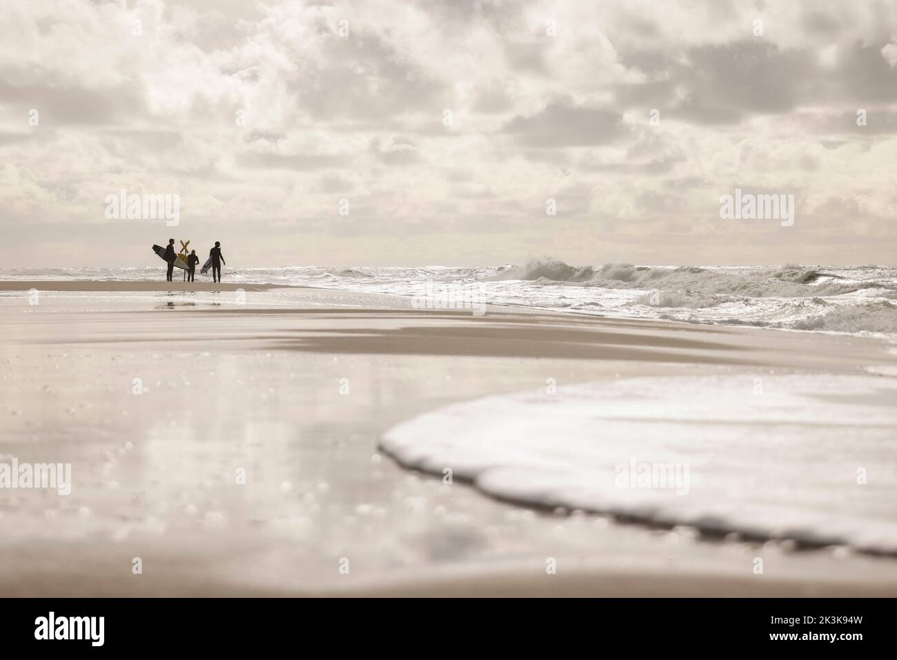 27 septembre 2022, Schleswig-Holstein, Westerland/Sylt: Trois surfeurs sont debout sur la plage de Brandebourg. Photo: Frank Molter/dpa Banque D'Images