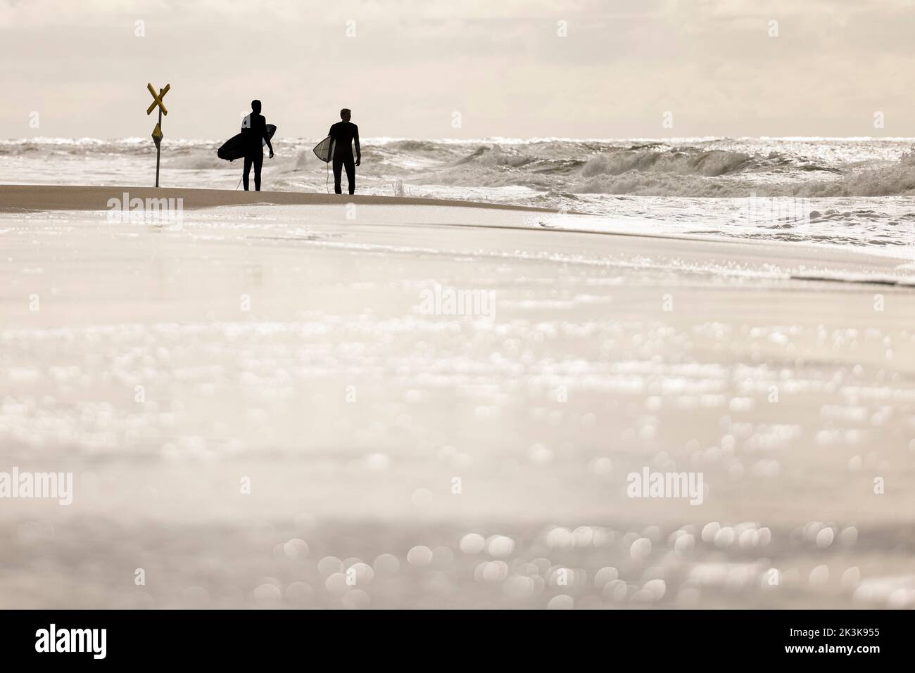 27 septembre 2022, Schleswig-Holstein, Westerland/Sylt: Deux surfeurs sont debout sur la plage de Brandebourg. Photo: Frank Molter/dpa Banque D'Images