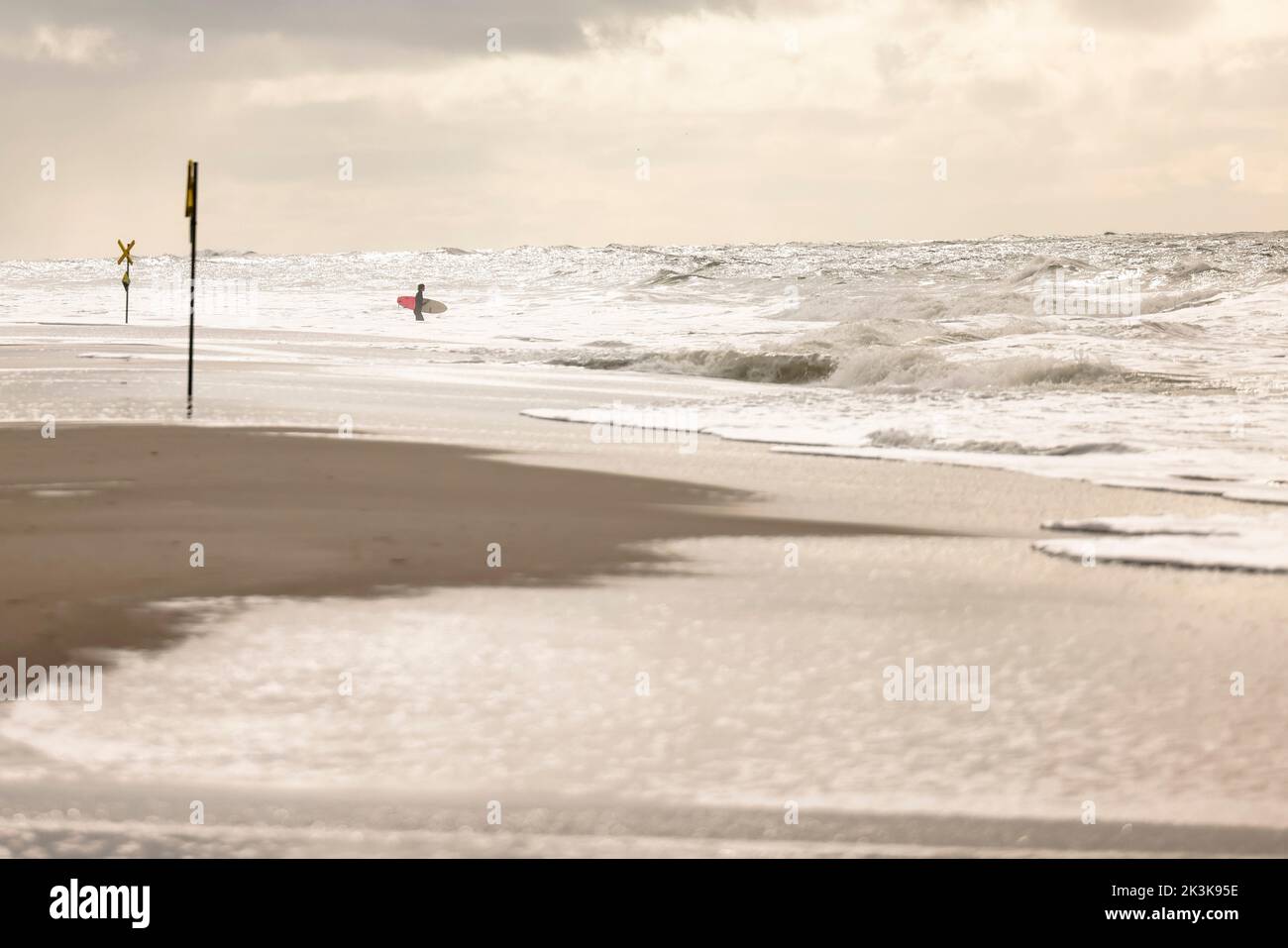 27 septembre 2022, Schleswig-Holstein, Westerland/Sylt : un surfeur se trouve sur la plage de Brandebourg. Photo: Frank Molter/dpa Banque D'Images