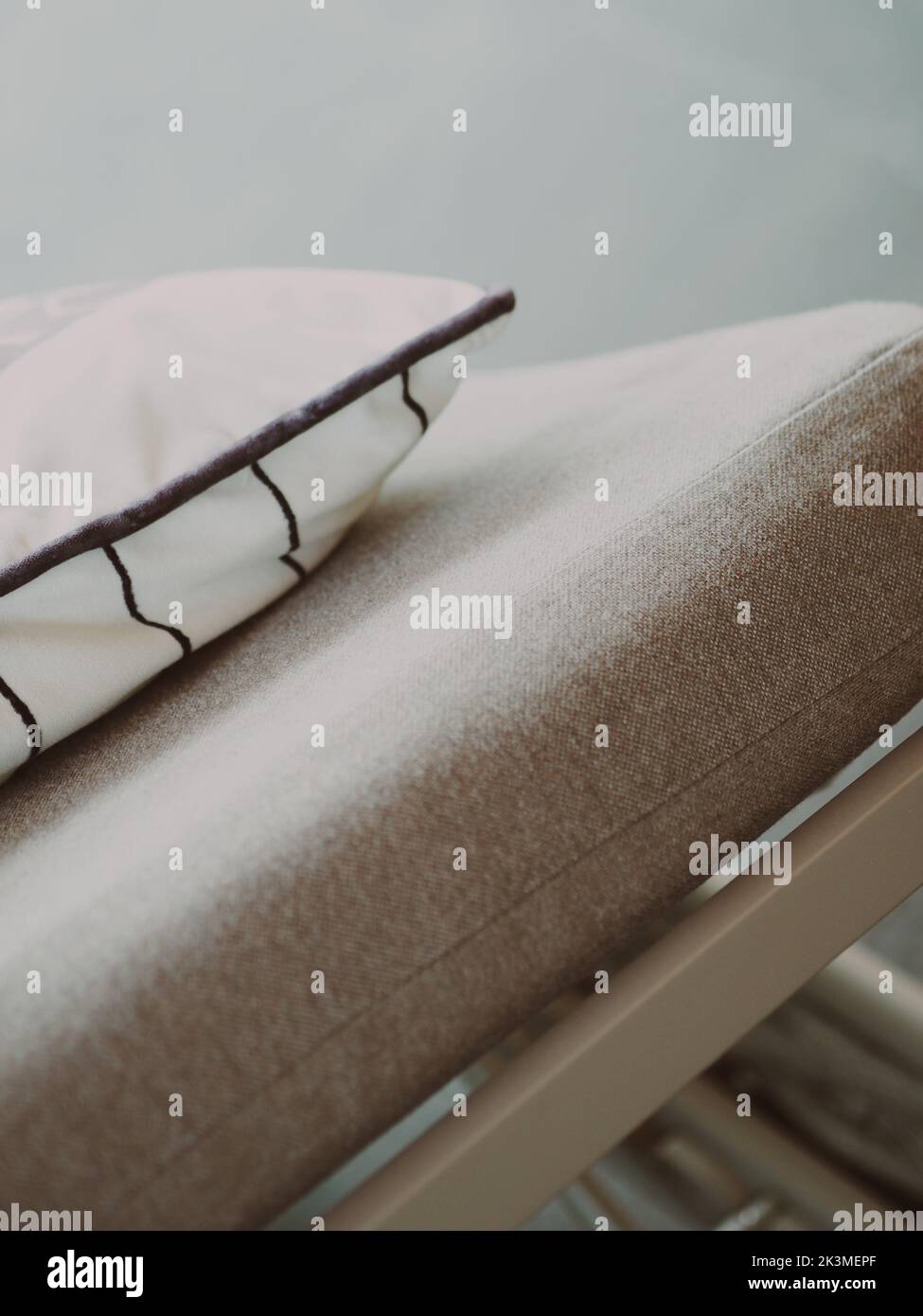Un cliché vertical d'un détail d'un canapé beige avec un oreiller Banque D'Images