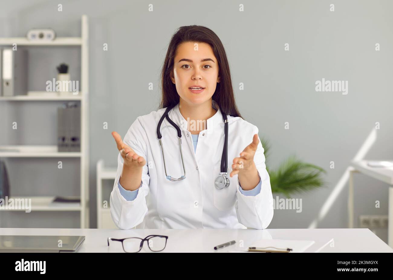 Portrait d'une femme médecin en manteau médical blanc donnant une consultation en ligne sur appel vidéo Banque D'Images
