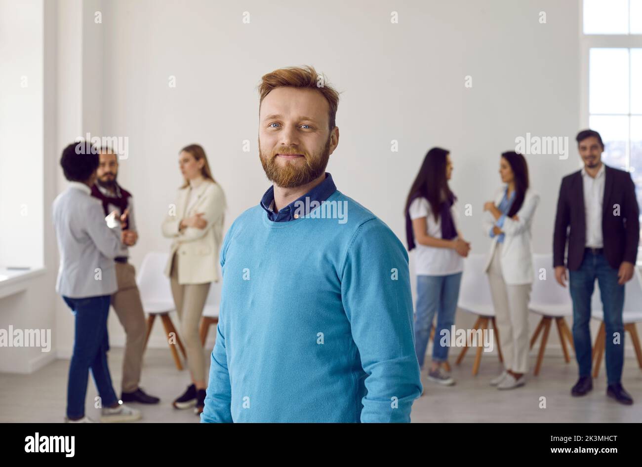Portrait d'un homme d'affaires ou d'un employé de bureau heureux debout au bureau et regardant l'appareil photo Banque D'Images