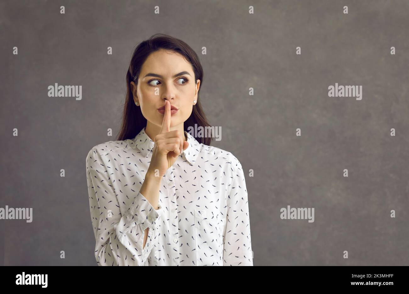 Portrait d'une belle jeune femme faisant un geste de shush vous demandant de garder son secret Banque D'Images