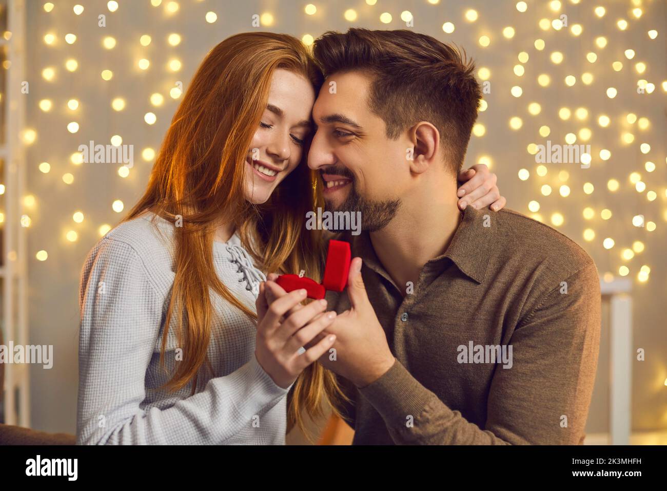 Heureux couple embrassant et regardant le ring après que la femme a dit oui et a accepté la proposition de mariage Banque D'Images