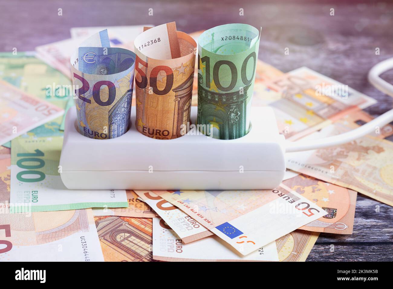 Prise avec des billets européens et plus d'euro sur une surface en bois Banque D'Images