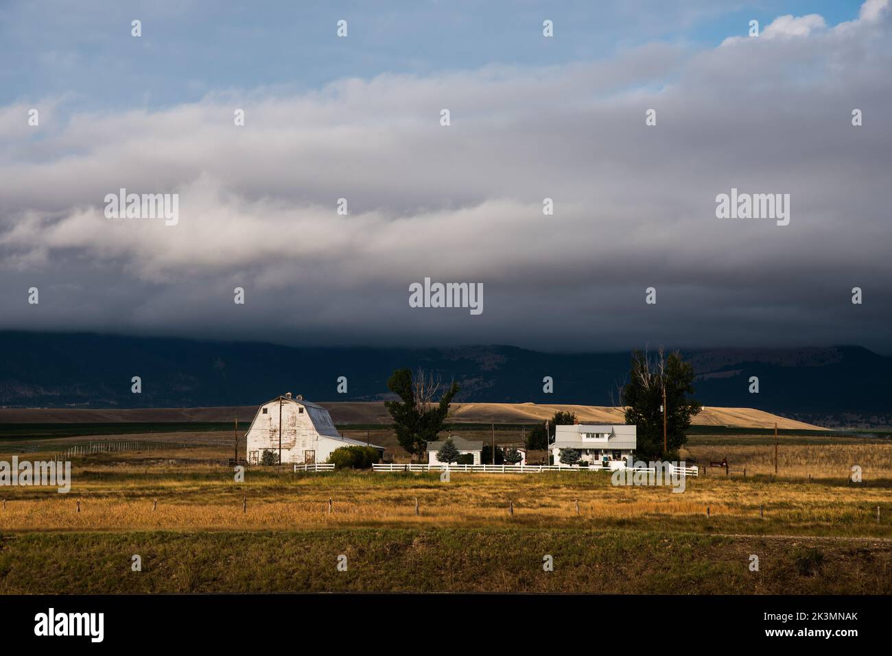 Grange blanche et ferme à Deer Lodge, Montana, États-Unis. Le Montana est connu sous le nom de « grand pays du ciel » pour ses vastes espaces ouverts et sa population clairsemée. Banque D'Images