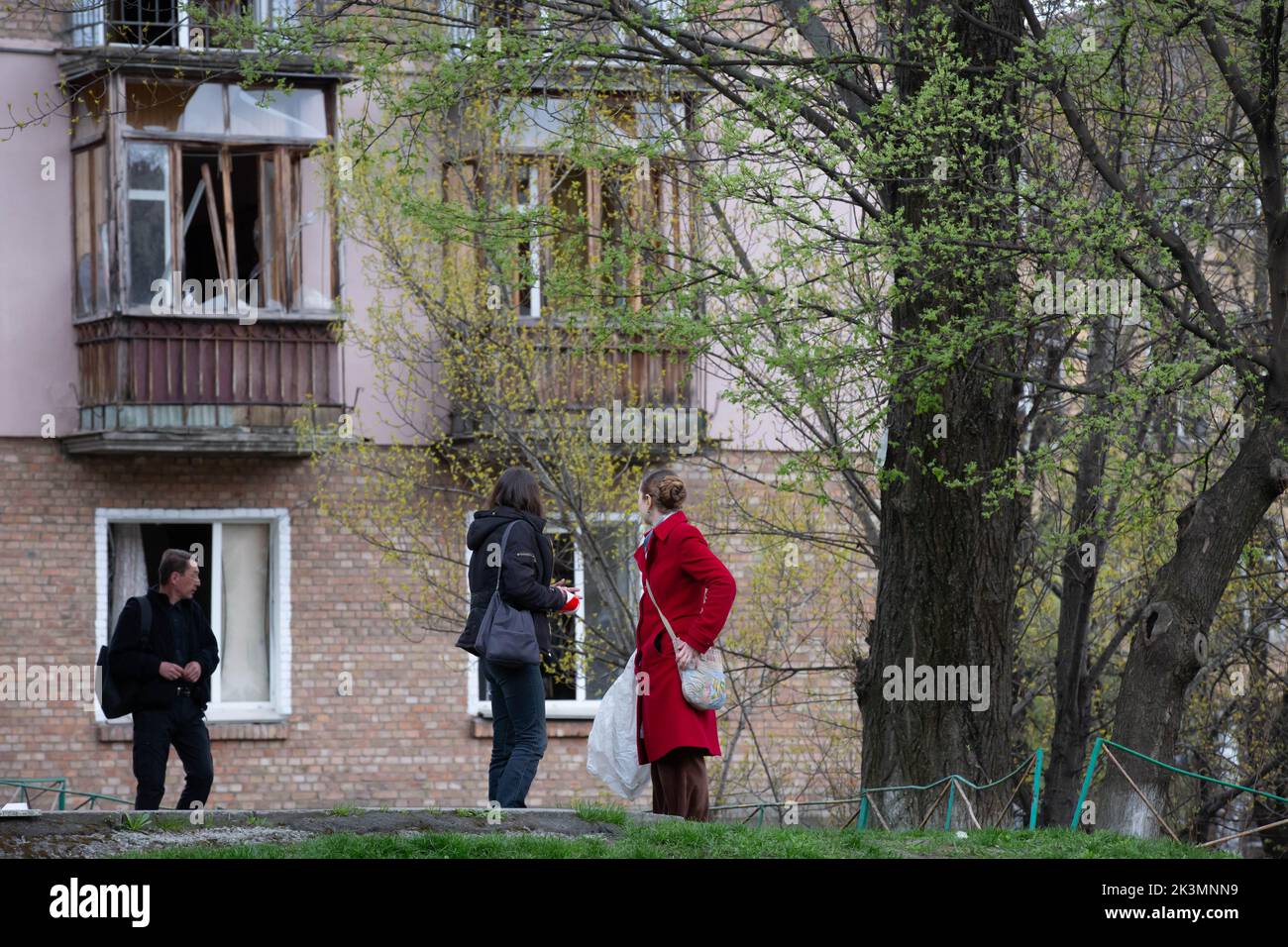 Les gens se tiennent près d'un immeuble d'appartements détruit lors d'une grève militaire au cours de l'invasion de l'Ukraine par la Russie à Kiev. Banque D'Images