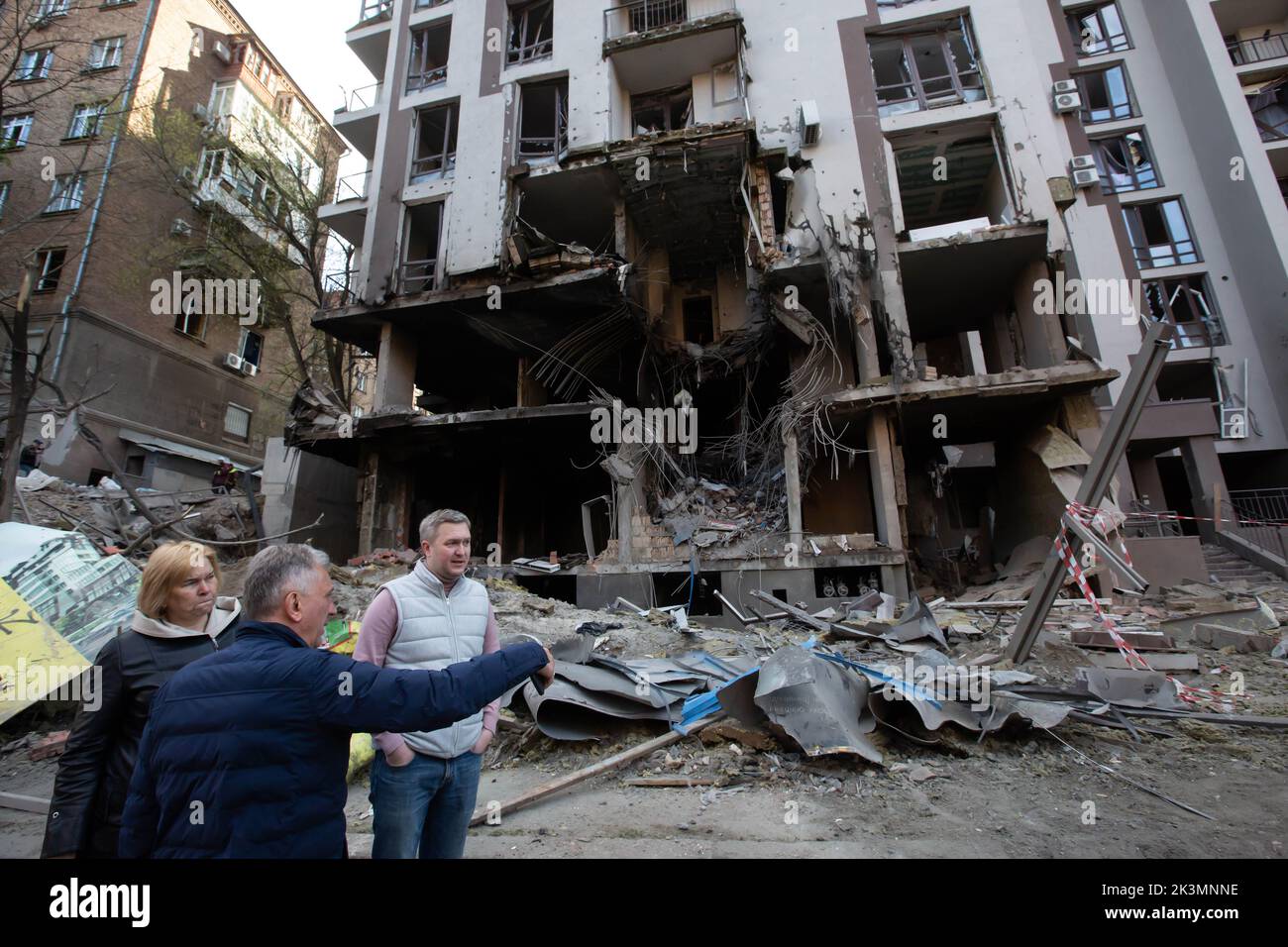 Les gens se tiennent près d'un immeuble d'appartements détruit lors d'une grève militaire au cours de l'invasion de l'Ukraine par la Russie à Kiev. Banque D'Images