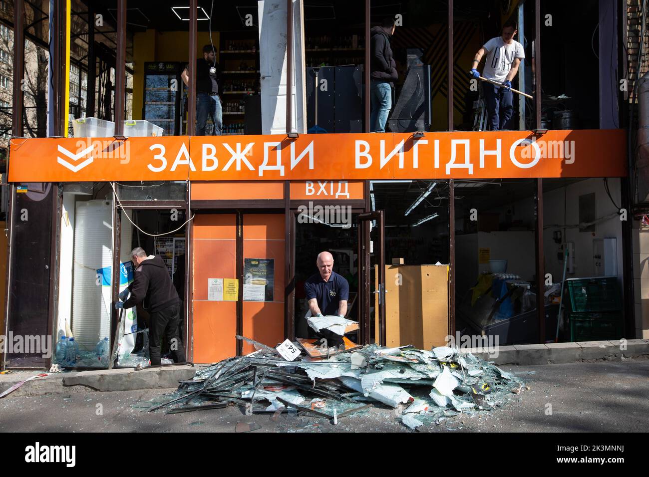 Les travailleurs nettoient les aires de commerce des supermarchés détruites lors d'une grève militaire au cours de l'invasion de l'Ukraine par la Russie à Kiev. Banque D'Images