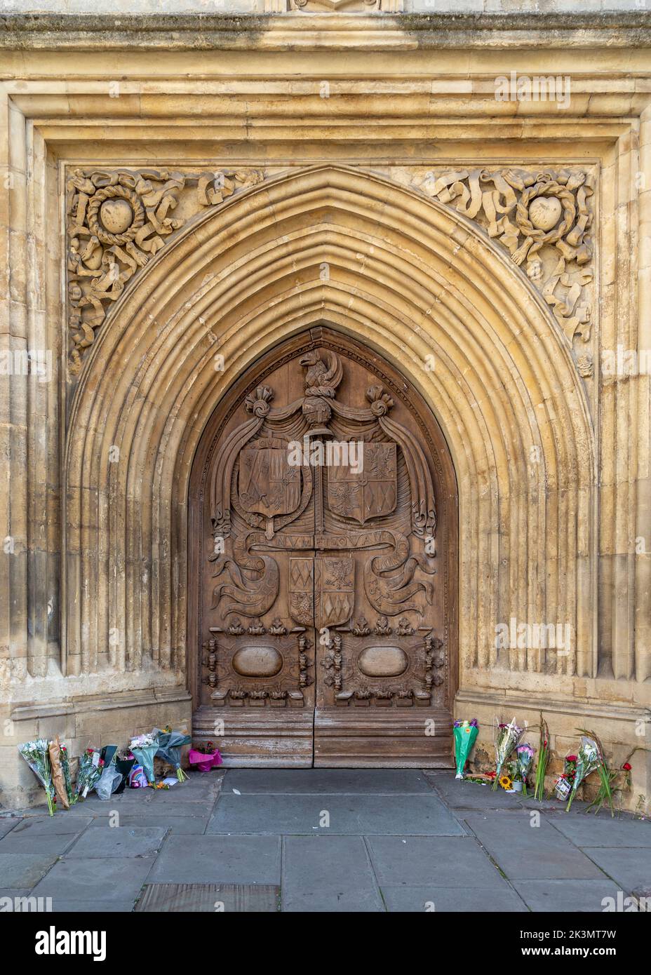 Porte ouest du 16th siècle à l'abbaye de Bath avec des hommages floraux à la reine QEII. Banque D'Images