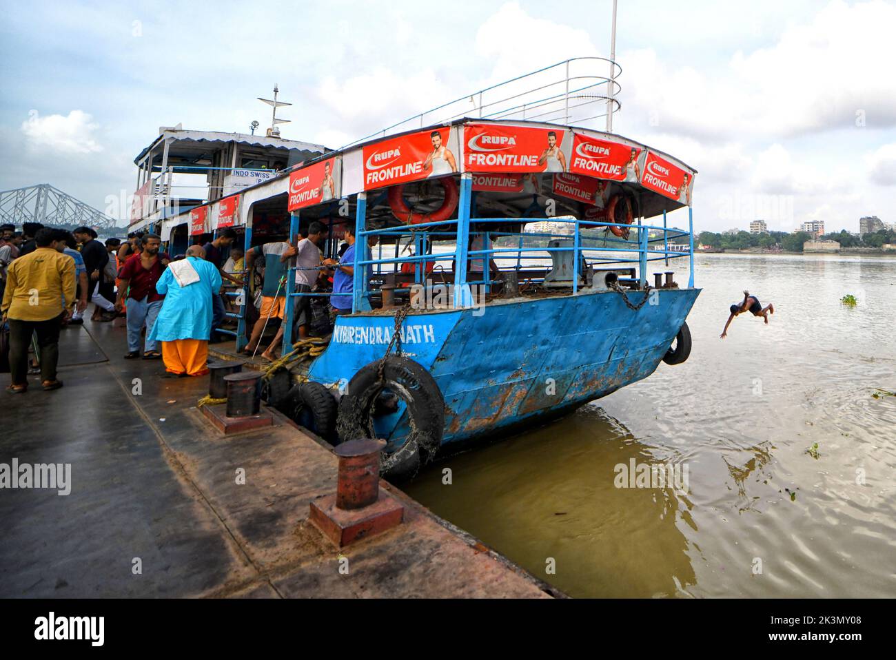 Un enfant saute dans le Gange à partir d'un navire à passagers. Banque D'Images