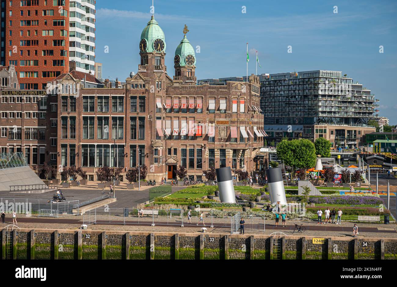 Rotterdam, pays-Bas - 11 juillet 2022 : hôtel historique en pierre brune de New York avec 2 tours à dôme vert sous le ciel bleu sur le quai et le quai de Kop van Zuid. PEO Banque D'Images