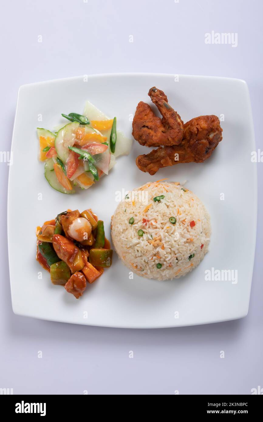 Schezwan poulet frit riz dans un bol blanc isolé sur fond blanc. Le riz Szechuan est un plat indo-chinois de cuisine avec poivrons, haricots verts, voiture Banque D'Images