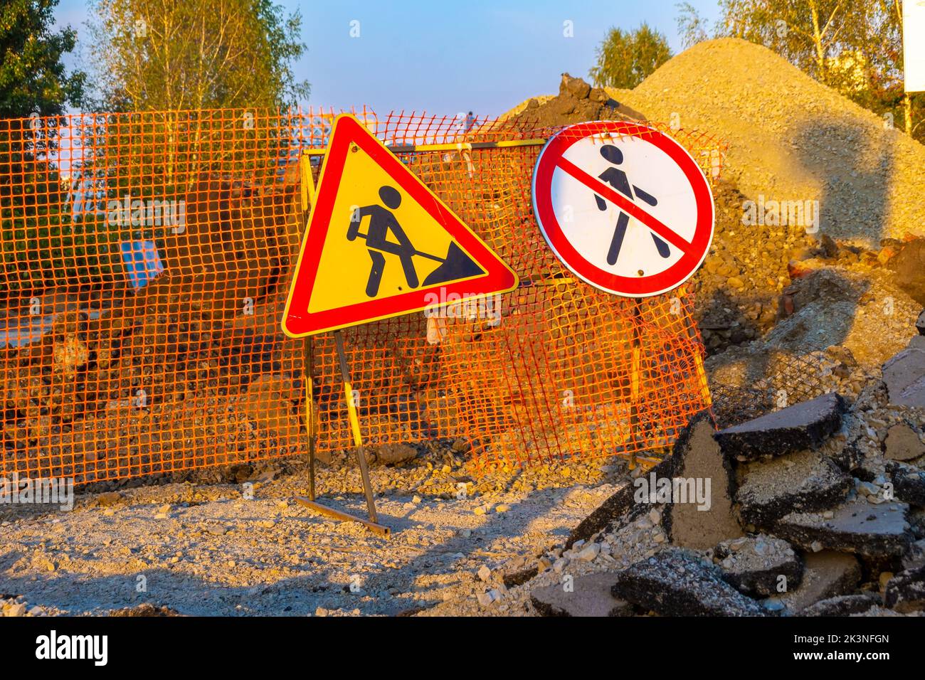 des panneaux de signalisation indiquant les travaux de réparation et interdisant le passage sont installés sur une clôture temporaire dotée d'une grille d'urgence orange, avec une attention sélective Banque D'Images