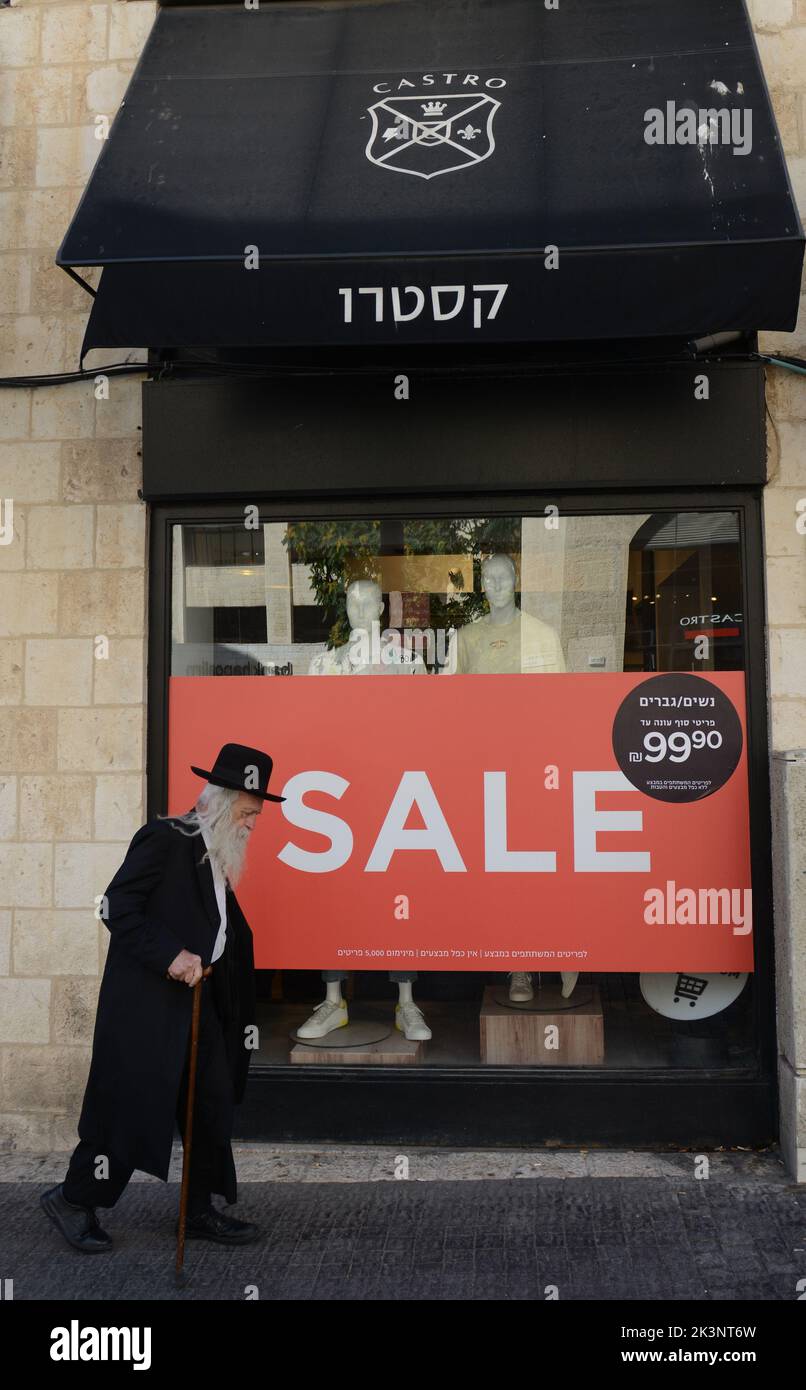 Un homme des religions israéliennes marchant à côté de la boutique de vêtements Castro sur la rue King George V à Jérusalem, Israël. Banque D'Images