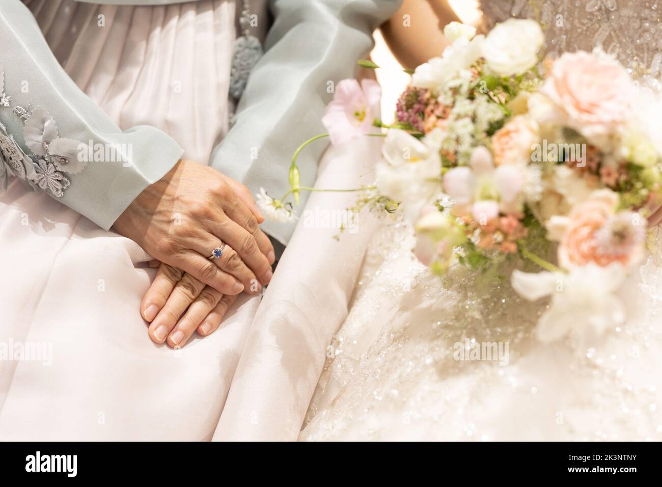 Main de la mère de marié à côté de la mariée le jour du mariage, en gros plan Banque D'Images