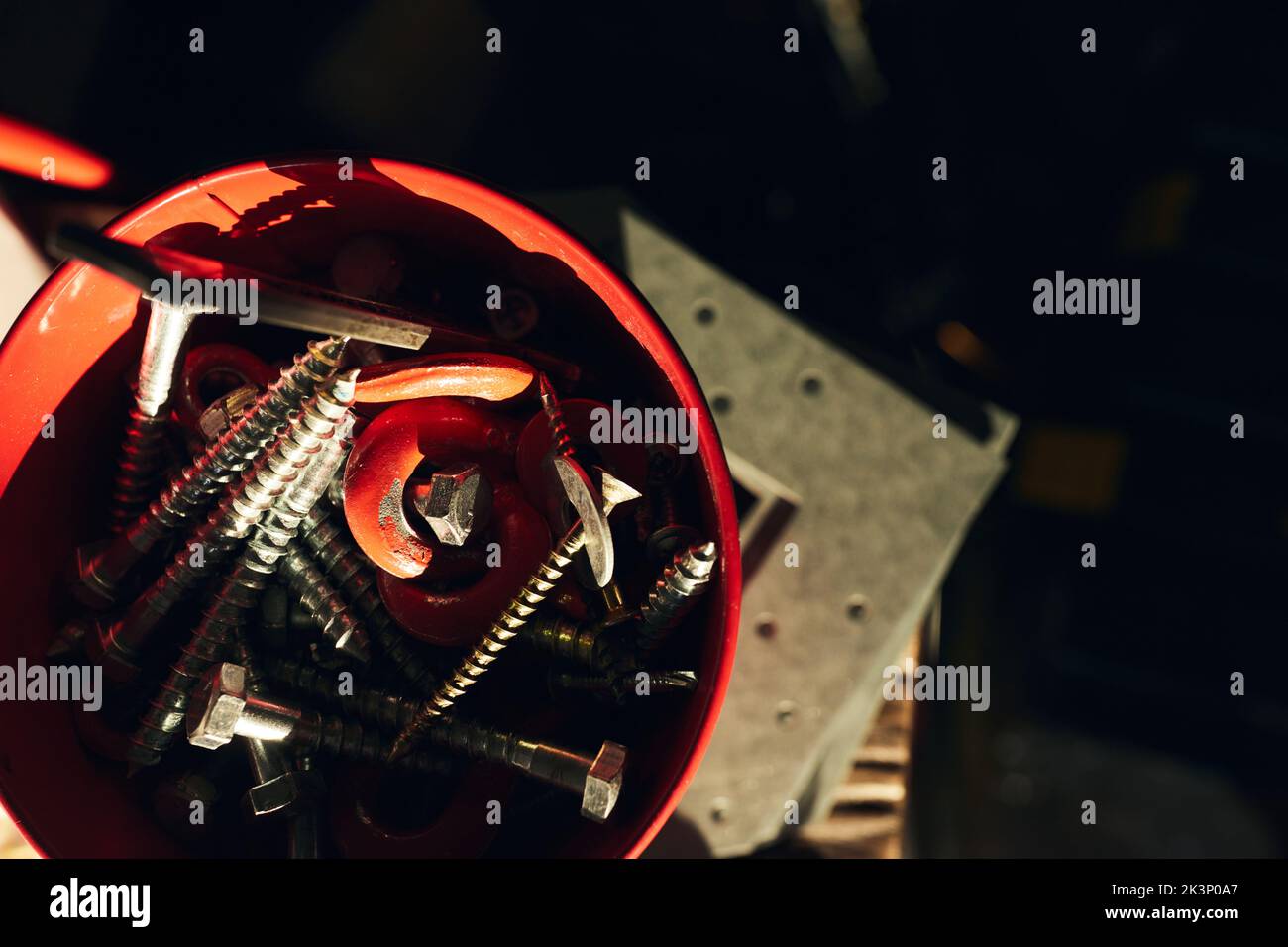 Vis autotaraudeuses et clé hexagonale sur un chantier de construction dans une cuvette en plastique. Vue avant. Banque D'Images